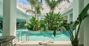 a swimming pool with plants in a building at Blue Sea Island in Kolimbia