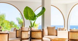 a lobby with wicker chairs and a plant at Blue Sea Island in Kolimbia