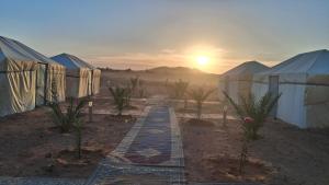 メルズーガにあるDesert Camel Trekのテントと夕日のある砂漠の景色