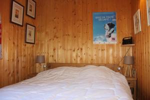 Un dormitorio con una cama en una pared de madera. en Comfortable Apartment With Terrace In Chamonix, en Chamonix-Mont-Blanc 8 fotos más
