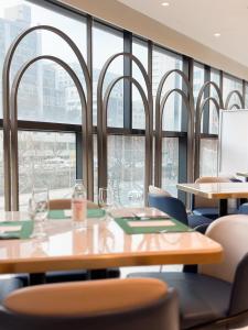 a conference room with tables and chairs and windows at Ibis Ambassador Suwon in Suwon