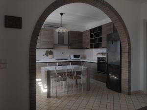 une voûte dans une cuisine avec une table et des chaises dans l'établissement Villa Serena, secret garden - 7 min Noventa Outlet, à Santa Maria di Campagna