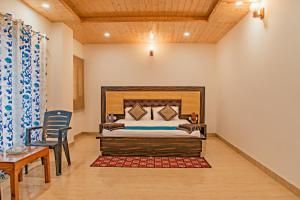 a bedroom with a bed and a table and chairs at The Woods View I Vacations I Family Groups & Events I Forest Treks I Memories Toy Train View I Serviced Apartments I Kasauli By Exotic Stays in Kasauli