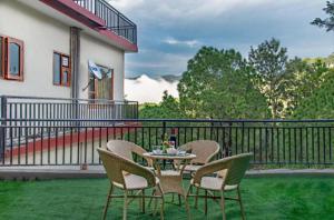 a patio with a table and chairs on the grass at The Woods View I Vacations I Family Groups & Events I Forest Treks I Memories Toy Train View I Serviced Apartments I Kasauli By Exotic Stays in Kasauli