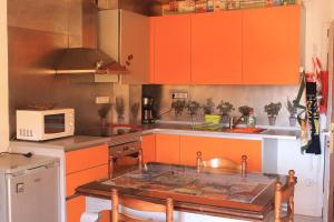 una cocina con armarios naranjas y una mesa. en Ap-Art, en La Seu d'Urgell