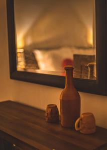 a bottle and two mugs sitting on a table at Riverview Bentota in Bentota