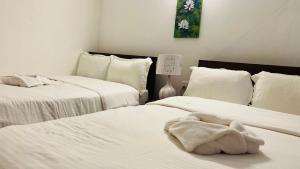 two beds in a room with white sheets at Riverview Bentota in Bentota