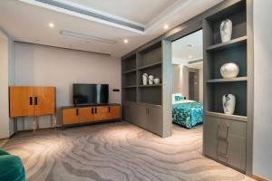 花都にあるZhengsheng Honggu Hotel - Guangzhou Sunac Cultural Tourism City Huadu Plazaのリビングルーム(テレビ付)、ベッドルーム1室 +15枚の写真
