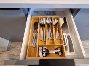 eine mit Küchenutensilien gefüllte Schublade in einer Küche in der Unterkunft Apartamenty Łódź5-Piotrkowska 100m, Manufaktura 1km, Atlas-Arena, parking w budynku in Łódź