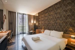 a hotel room with a large bed and a desk at Cove Southouse Residence in Jakarta
