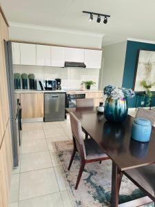 a kitchen with a wooden table with a vase on it at The Blyde Crystal Lagoon 3BEDROOM in Pretoria
