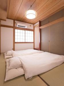 a large white bed in a room with a window at 大戸別邸 Oto Villa 小江戸佐原や鹿島香取神宮観光にも便利な一棟貸しの宿 in Katori