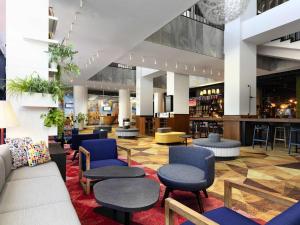 a lobby with chairs and tables and a bar at Novotel Poznan Centrum in Poznań