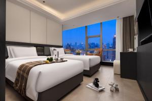 a hotel room with two beds and a large window at Borui Starry Sky View Hotel (Chongqing Jiefangbei Pedestrian Street Hongyadong Branch) in Chongqing