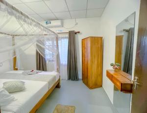a bedroom with two beds and a wooden cabinet at 7 S Villa & Cottage in Kamburugamuwa