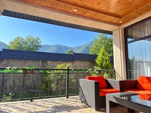 ガバラにあるQafqaz Qabalandia Deluxeのバルコニーにテーブルと椅子が置かれたパティオ