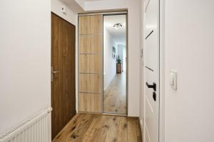 ein Flur mit einer Glastür und ein Flur, der in einen Raum führt in der Unterkunft Apartament Szafirowy Paderewskiego 47a Dzielnica Parkowa Rzeszów in Rzeszów