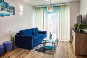 ein Wohnzimmer mit einem blauen Sofa und einem Tisch in der Unterkunft Apartament Szafirowy Paderewskiego 47a Dzielnica Parkowa Rzeszów in Rzeszów