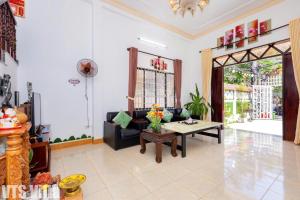 a living room with a couch and a table at Villas Hồ Bơi HM Bãi Sau Thoáng Mát Sân BBQ in Vung Tau