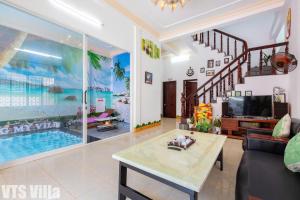 a living room with a tv and a pool at Villas Hồ Bơi HM Bãi Sau Thoáng Mát Sân BBQ in Vung Tau