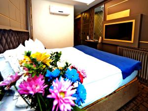 ein Schlafzimmer mit einem Bett mit Blumen auf einem Tisch in der Unterkunft Grand Best Nobel Hotel İstanbul in Istanbul