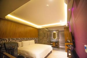 a bedroom with a bed and a tv in it at LE LE Motel in Pingtung City