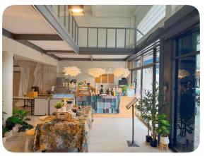 a room with two tables and a kitchen with windows at Omalaya Bangkok in Samphanthawong