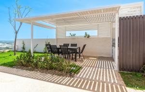 a patio with a table and chairs under a pergola at Awesome Home In Marina Di Ragusa in Marina di Ragusa