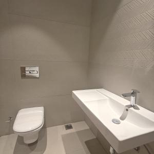a white bathroom with a sink and a toilet at Bluestone Prime by The Cosy Hotels in New Delhi +76 photos