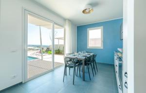 a dining room with blue walls and a table with chairs at Awesome Home In Marina Di Ragusa in Marina di Ragusa