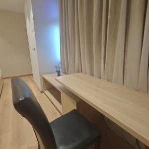 a desk with a chair in a room with a window at Bluestone Prime by The Cosy Hotels in New Delhi