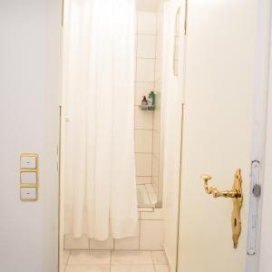a shower with a white shower curtain in a bathroom at Villa Burgau in Monschau +69 photos