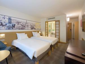 a hotel room with two beds and a desk at Novotel Aachen City in Aachen +95 photos