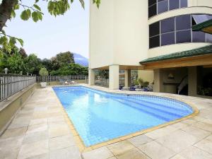 a swimming pool in front of a building at Mercure Jaragua do Sul in Jaraguá do Sul