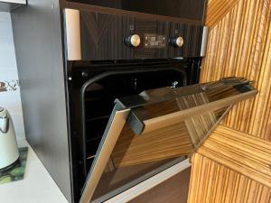 a microwave oven with a door open in a kitchen at Azimut in Šiauliai
