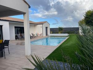 a backyard with a swimming pool and a house at maison la rochelle 3 étoiles in Marsilly