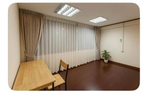 an empty room with a table and a potted plant at Omalaya Bangkok in Samphanthawong