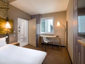 a hotel room with a bed and a desk and a bathroom at ibis Hotel Hamburg St. Pauli Messe in Hamburg