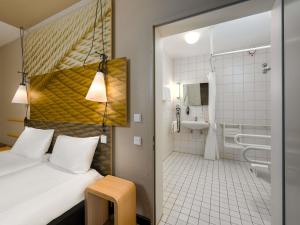 a hotel room with a bed and a bathroom at ibis Hotel Hamburg St. Pauli Messe in Hamburg +112 photos
