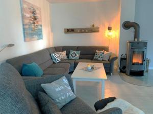 een woonkamer met een bank en een open haard bij Landhaus Scholz in Dollerup