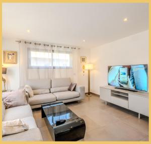 ein Wohnzimmer mit Couch und Flachbildfernseher in der Unterkunft Chez Inès I Villa aux portes de Genève in Feigères