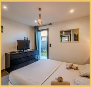 ein Schlafzimmer mit einem großen Bett und einem Fernseher in der Unterkunft Chez Inès I Villa aux portes de Genève in Feigères