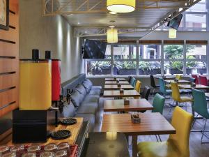 a restaurant with couches and tables and chairs at Ibis Maringa in Maringá