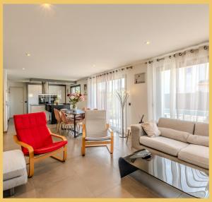 ein Wohnzimmer mit Sofa, Stühlen und einem Tisch in der Unterkunft Chez Inès I Villa aux portes de Genève in Feigères