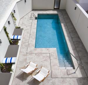 an overhead view of a swimming pool with two chairs at El Jazmín del Patio in Nerja