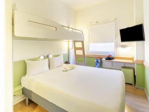a bedroom with a large white bed and a bunk bed at Ibis Budget Madrid Calle Alcalá in Madrid +69 photos