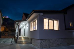 a white house with windows and stairs at night at Casa Branga in Deva