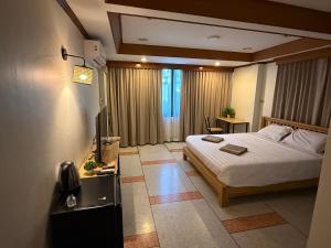 a bedroom with a bed and a television in it at Omalaya Bangkok in Samphanthawong