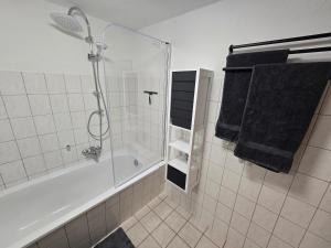 a bathroom with a shower and a bath tub with towels at FERIENWOHNUNG 52m2 APARTMENT in ZITTAUER STADTZENTRUM INNENSTADT INNENRING TOP LAGE - WOHNEN AUF ZEIT IN ZITTAU - 2 RAUM WOHNUNG EINKAUFSSTRASSE in Zittau +23 photos