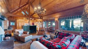 HomewoodにあるHomewood Lakefront by AvantStay Private Beach Lake Access Viewsのリビングルーム(ソファ、椅子、シャンデリア付)
